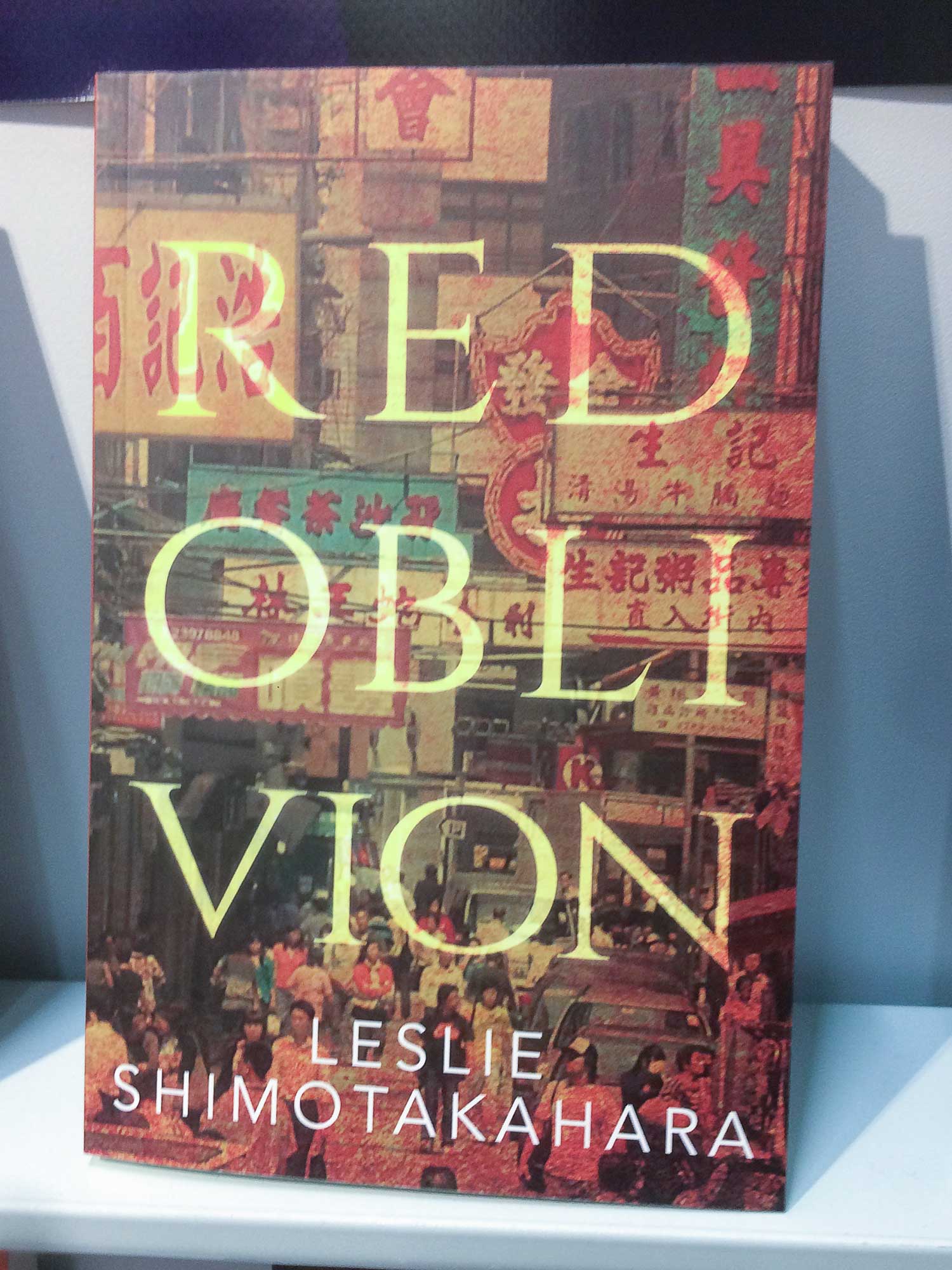 Red-Oblivion Dies ist ein Foto des Buches "Red Oblivian". Der Umschlag zeigt ein Foto von vielen asiatischen Läden mit einer eleganten serif Beschriftung des Titelnamens in gold-gelb