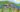Illustration: Überarbeiteter Auszug der Rückseite von »Die Kurpfalz wimmelt«. Der Hintergrund zeigt den Neckar und den Heidelbergerschloss. Die Sonne scheint und der Himmel ist blau mit weichen Wolken. Im Vordergrund sind zehn Kindergartenkinder, die vier Kornmäuse, eine Erzieherin und einen Erzieher sowie zwei lustige Störche und zwei Spargelfiguren, die im Roten Cabriolet sitzen. Illustration ©Kimberley Hoffman